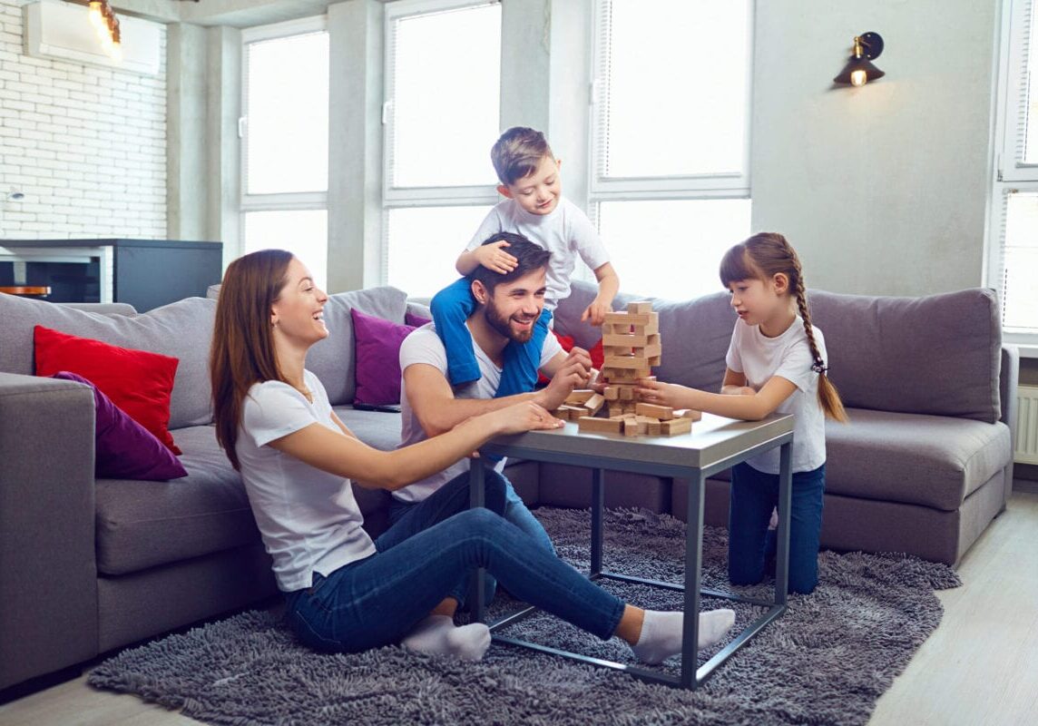 Happy family playing board games at home. Mother, father and children play together.